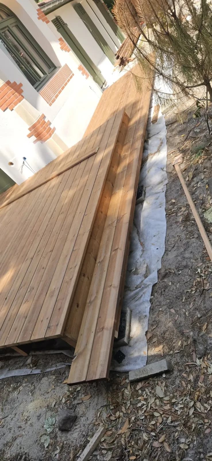 Pose des lames d’une terrasse en bois sur géotextile
