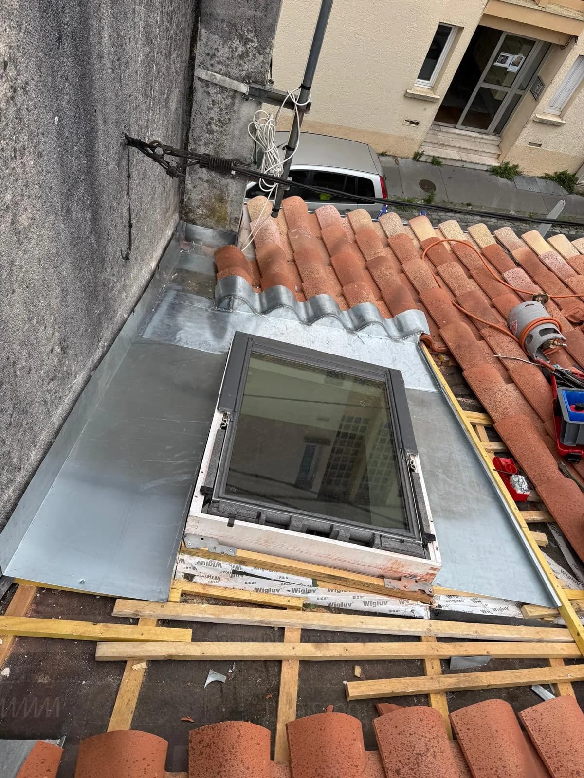 Raccord d’étanchéité en zinc autour d’une fenêtre de toit sur tuiles canal