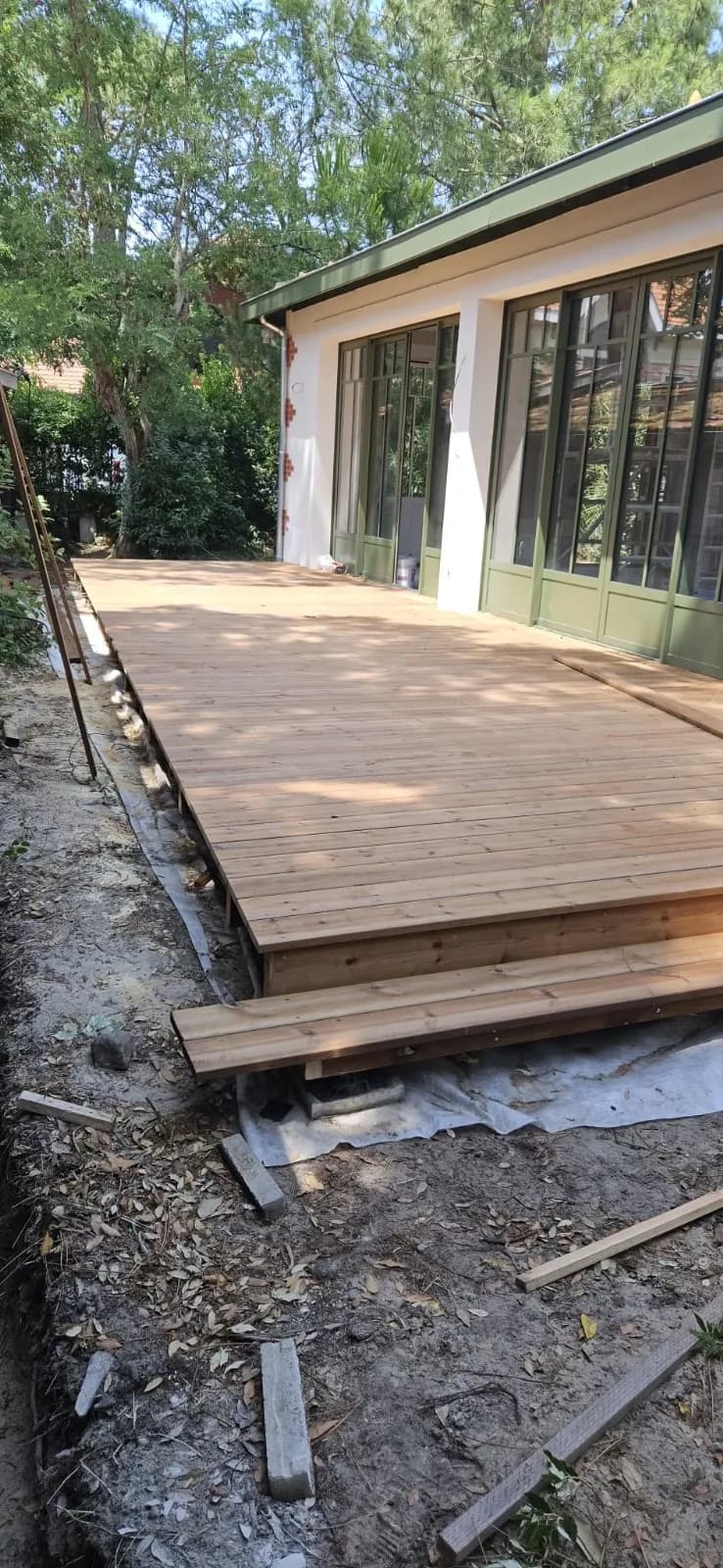 Terrasse en bois posée devant une véranda
