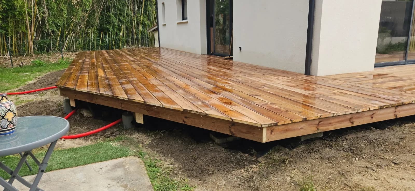 Terrasse en bois sur plots au pied d’une maison neuve