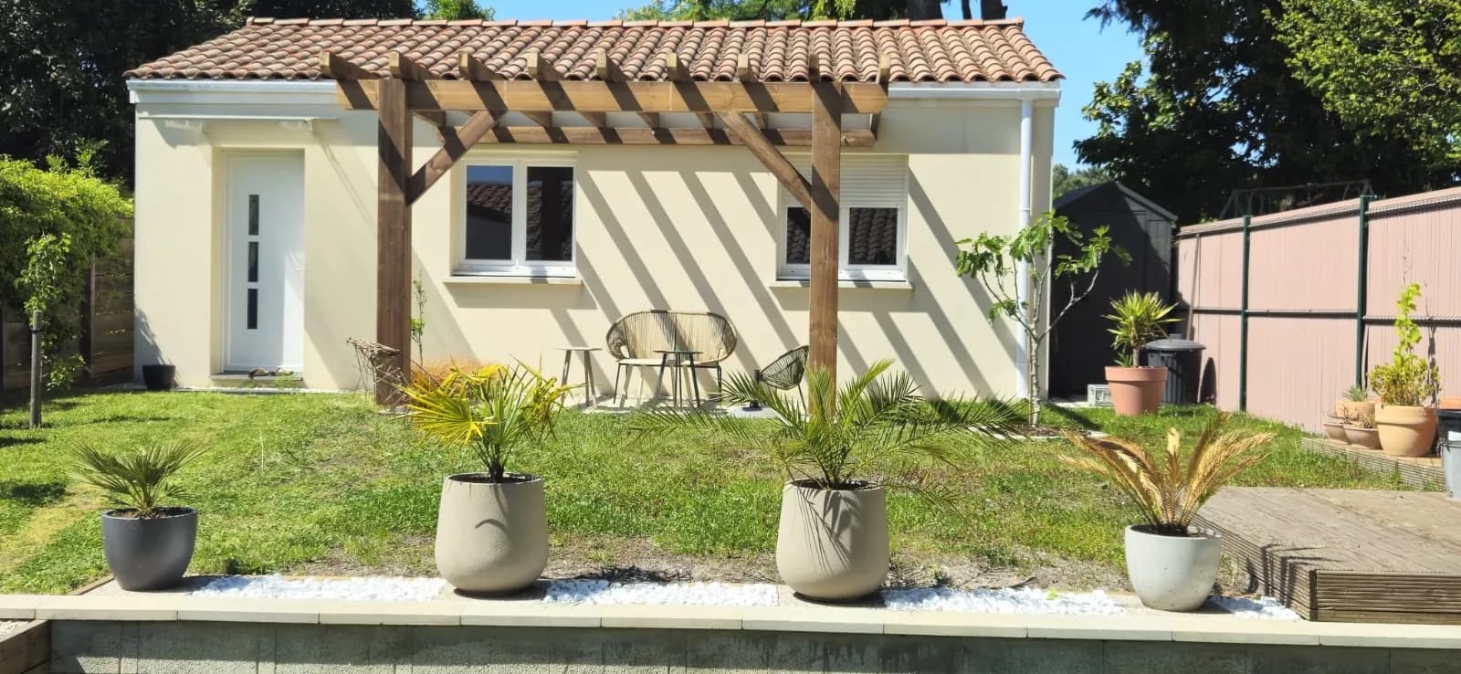 Pergola en bois massif devant une maison avec jardin