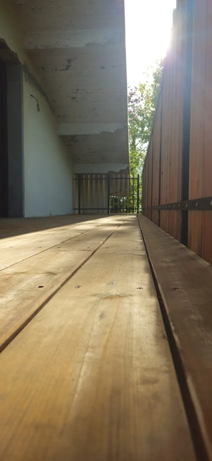 Coursive étroite en lames de bois le long d’une façade