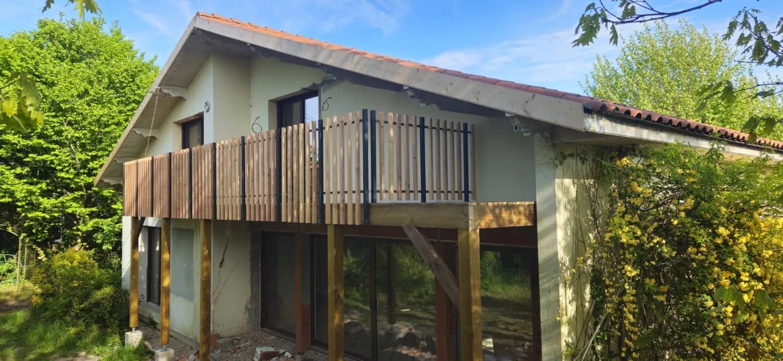 Balcon en bois avec garde-corps à claire-voie sur une maison