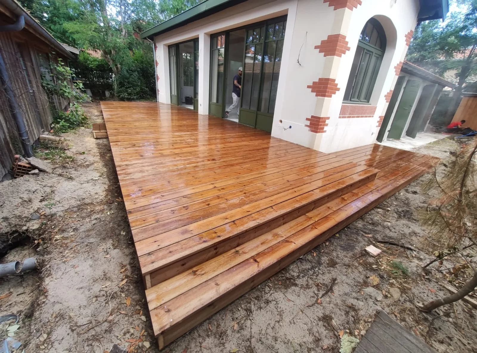 Grande terrasse en bois devant une maison girondine